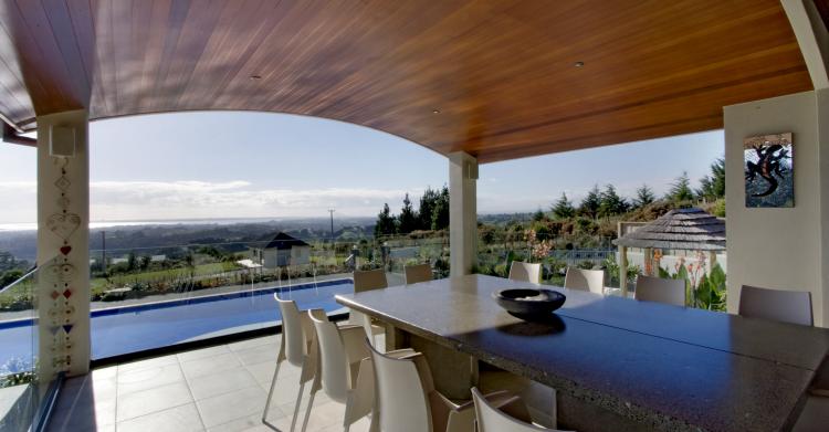 Alfresco dining overlooking the pool and landscaped gardens